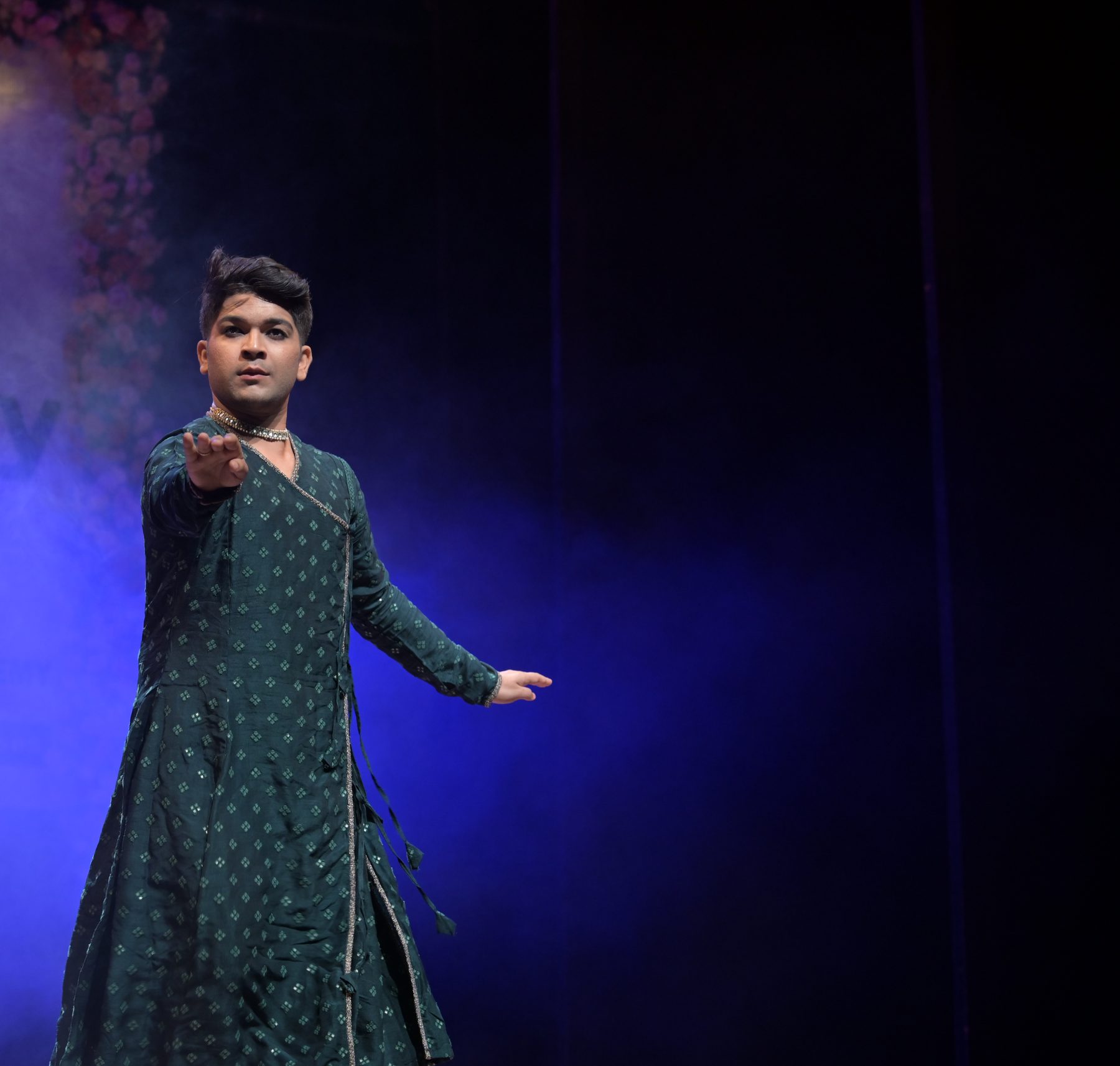 Kathak dancer reaching forward with an outstretched hand
