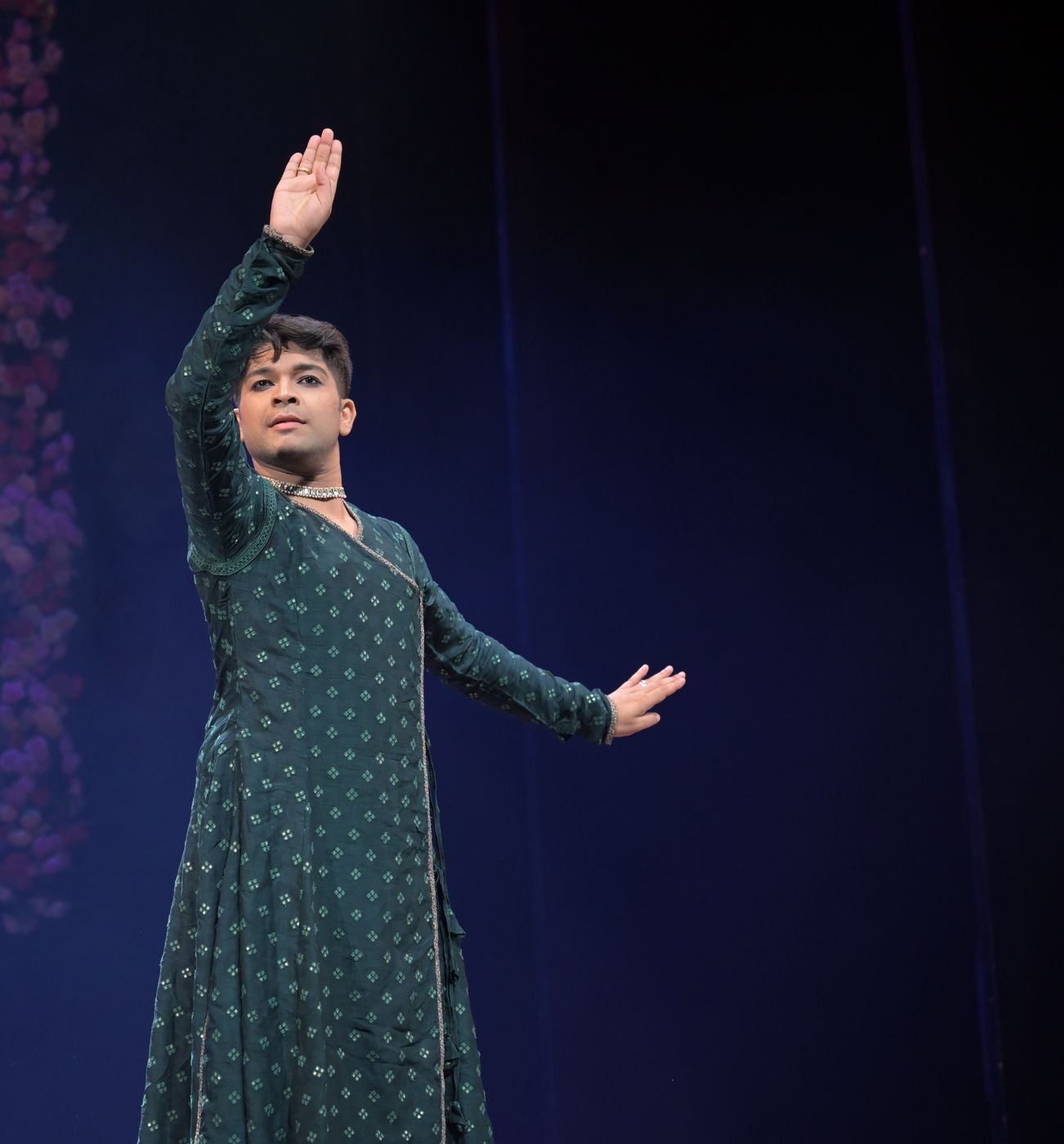 Kathak dancer with one arm raised in a graceful pose