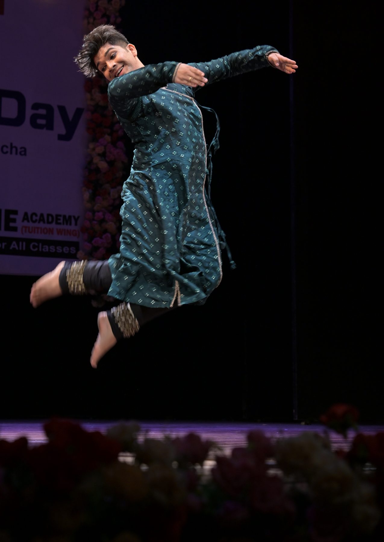 Kathak dancer captured mid-jump, arms and skirt in motion